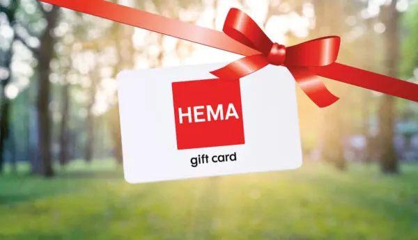 Hema bon met op de achtergrond een groen bos. Er valt een rode strik over bij wijze van cadeau.